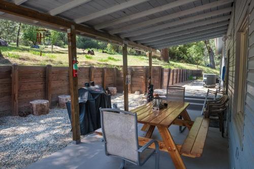 a patio with a wooden table and chairs at Magic Escape in Oakhurst