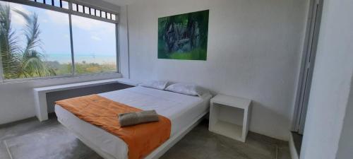a bedroom with a bed and a large window at ALEWA, apartamento. Dibulla la Guajira in Dibulla