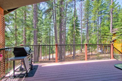 a porch with a grill on a wooden deck with trees at Serenity Pines in Yosemite West