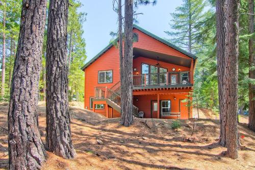 a red cabin in the woods with trees at Serenity Pines in Yosemite West