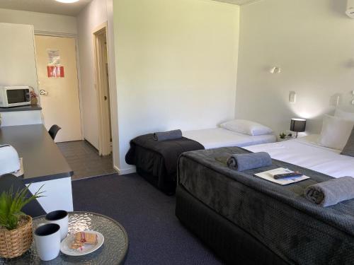 a hotel room with two beds and a table at Mid City Motor Inn in Mackay