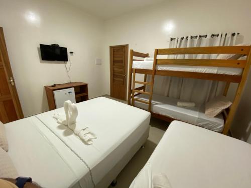 a room with two bunk beds and a television at Pousada Casa da Cion in Jericoacoara