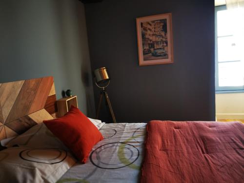 a bedroom with a bed with red pillows and a window at La Mirabelle des 3 Forêts in Bricon