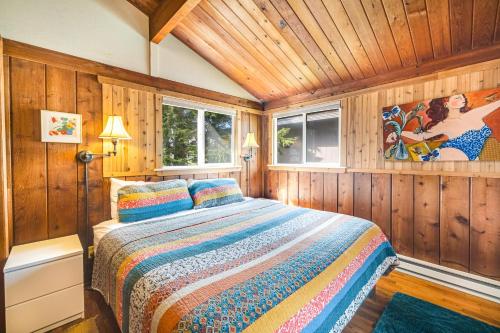 a bedroom with a bed in a room with wooden walls at The Lily Pad in Rockaway Beach