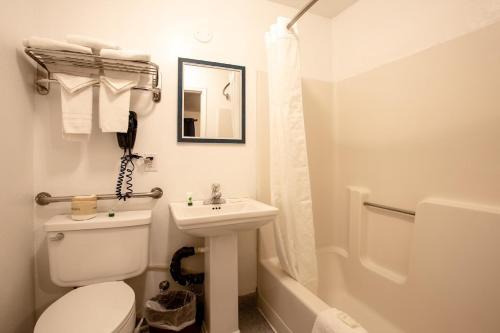 Baño blanco con aseo y lavamanos en Celilo Inn, en Williams