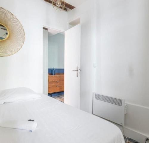 a white bedroom with a bed and a mirror at LE MARAIS-SAINT MARTIN LUXURY & DESIGN BY STUDIO in Paris