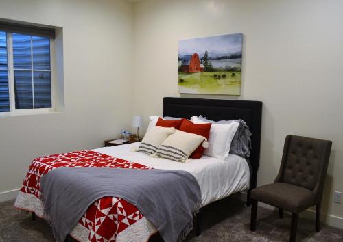 1 dormitorio con 1 cama, 1 silla y 1 pintura en Sevier River Farmhouse 1, en Hatch