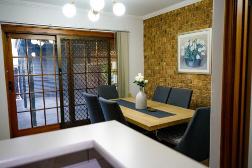 una sala da pranzo con tavolo e sedie in legno di Adelaide Style Accommodation-Getaway in North Adelaide- close to city a Adelaide