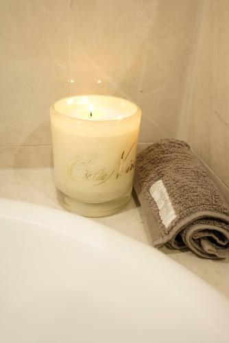 a candle sitting on a shelf next to a towel at Adelaide Style Accommodation-Getaway in North Adelaide- close to city in Adelaide