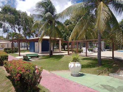 una villa con palmeras y un jarrón blanco en un patio en Apts e suites em Stella Maris, en Salvador