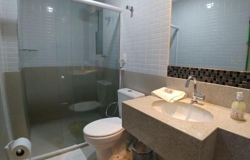 a bathroom with a sink and a toilet and a shower at Areias do Mar ! Charmoso e com Ar na Sala A318 in Barra de São Miguel