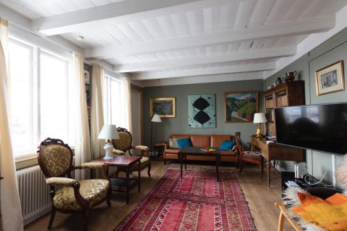 a living room with a couch and a tv at Downtown - Jørgen Frantz - Marina in Tórshavn
