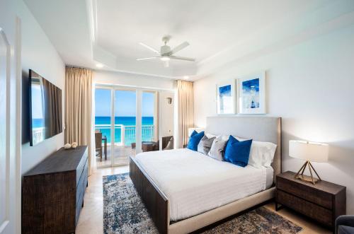 a bedroom with a bed with a view of the ocean at Club Se7en at Beachcomber in Upper Land