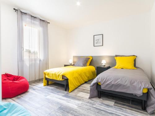 duas camas num quarto com amarelo e cinzento em Gîte Saint-Philbert-de-Grand-Lieu, 3 pièces, 4 personnes - FR-1-306-980 em Saint-Philbert-de-Grand-Lieu