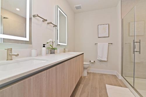 a white bathroom with a sink and a toilet at New Cozy & Spacious Townhouse near Disney - 4BR, 3FB, and Pool in Orlando