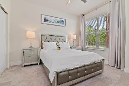 a bedroom with a large bed and a window at New Cozy & Spacious Townhouse near Disney - 4BR, 3FB, and Pool in Orlando