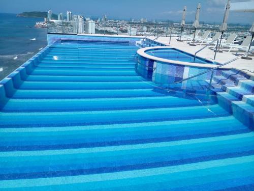 a swimming pool with blue steps on a ship at Departamento en el malecón, Torre Central 102 in Mazatlán