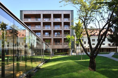 a glass building with a tree in front of it at Hotel Balnea Superior - Terme Krka in Dolenjske Toplice