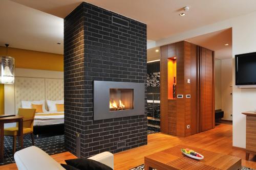 a fireplace in a living room with a bedroom at Hotel Balnea Superior - Terme Krka in Dolenjske Toplice