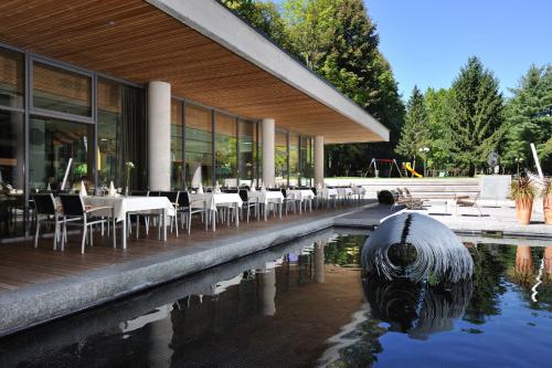 a restaurant with tables and chairs next to a swimming pool at Hotel Balnea Superior - Terme Krka in Dolenjske Toplice