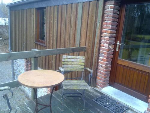 a table and a chair sitting on a balcony at Parkhotel Villa des Effats Vielsalm in Vielsalm