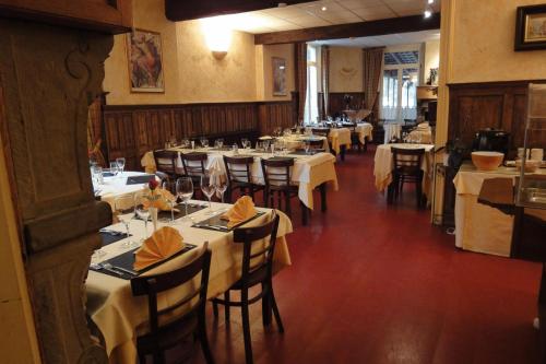 a restaurant with tables and chairs with white tablecloths at Parkhotel Villa des Effats Vielsalm in Vielsalm