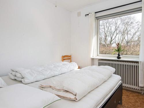 two beds in a white room with a window at 6 person holiday home in Nørre Nebel-By Traum in Nørre Nebel