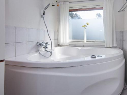 ヘンネ・ストランドにある6 person holiday home in Henneの白いバスルーム(バスタブ付)、窓が備わります。