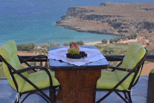 a table with chairs and a view of the ocean at Katerina Apartments in Káto Zákros