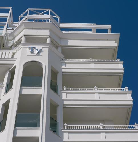 an apartment building with balconies against a blue sky at Hotel Tiffany's in Riccione