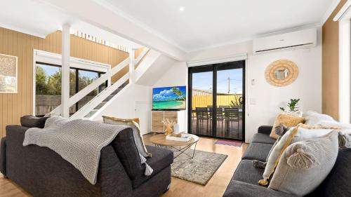 a living room with two couches and a staircase at Sunderland Retreat in Sunset Strip