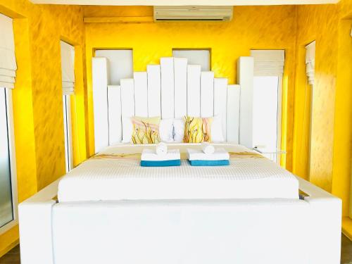 a bedroom with a large white bed with yellow walls at Best world vision in Chaweng