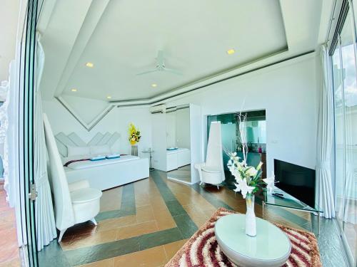 a living room with white furniture and a tv at Best world vision in Chaweng