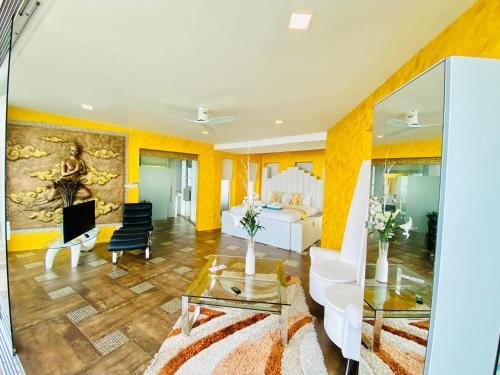 a living room with yellow walls and a white couch at Best world vision in Chaweng