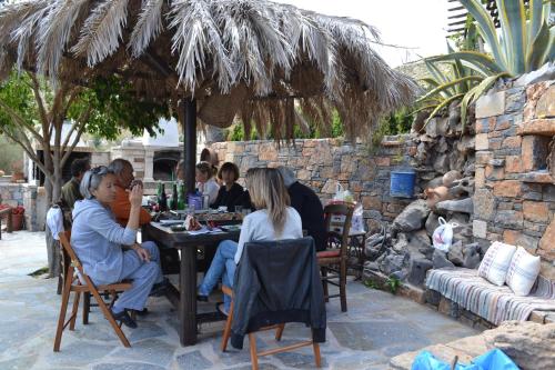 a group of people sitting at a table under an umbrella at Katerina Apartments in Káto Zákros
