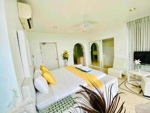 a white bedroom with a large bed and a tv at Best world vision in Chaweng