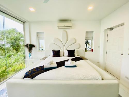 a white bedroom with a large bed with a large window at Best world vision in Chaweng