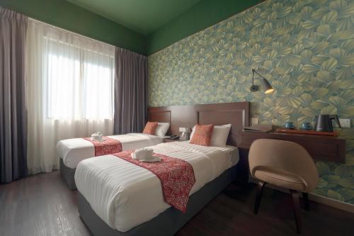 a hotel room with two beds and a chair at East Riverine Boutique Hotel in Kuala Lumpur