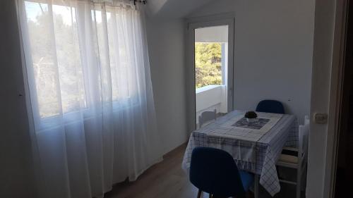 a room with a table and chairs and a window at Apartment Happy 3 in Pakoštane