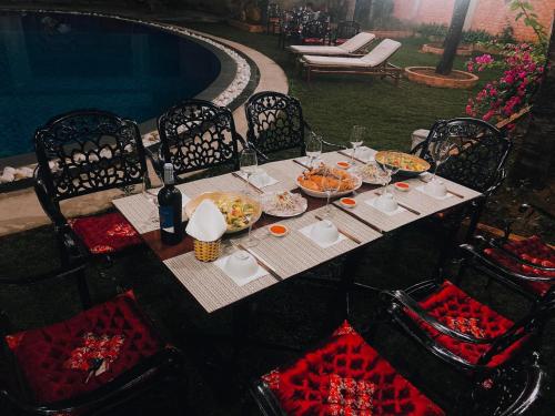 a table with plates of food on it next to a pool at Hung Vuong Resort in Phú Quốc