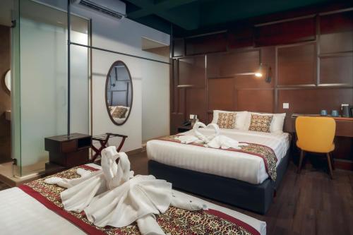 a hotel room with two beds and a mirror at East Riverine Boutique Hotel in Kuala Lumpur