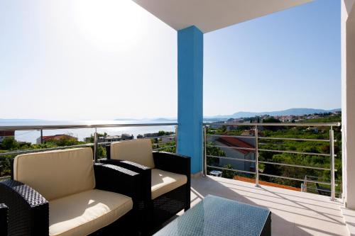 a balcony with couches and a view of the ocean at Family Villa Mermaid Your Croatian Haven with Pool and Scenic Views in Podstrana