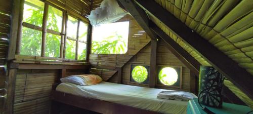 a bedroom in a tree house with windows at hostal Monte Libano in Puerto López