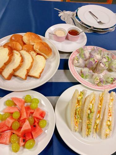 伊東市にある花水木温泉リゾートのサンドイッチとフルーツを盛り付けた食べ物を盛り付けたテーブル