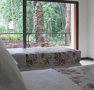 a bedroom with a bed and a large window at Hotel Sol Cataratas in Puerto Iguazú