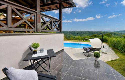 a patio with a table and chairs and a pool at 3 Bedroom Nice Home In Rukljevina in Gornja Poljana