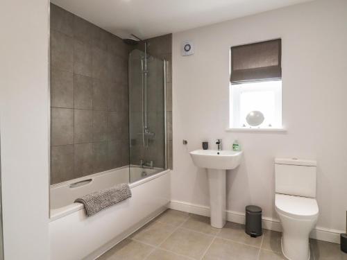 uma casa de banho com um lavatório, um WC e um chuveiro em Wising Gill House em Harrogate