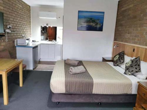 Habitación pequeña con cama y cocina en Peppinella Motel, en Ballarat