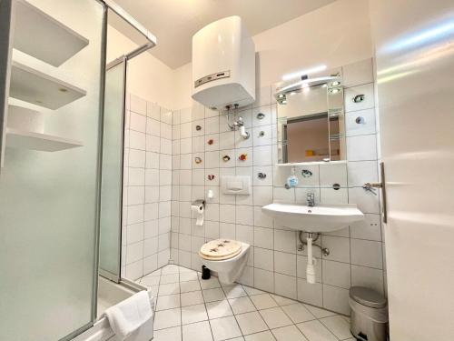 een witte badkamer met een toilet en een wastafel bij City Dream - Apartment Top 3 self check-in in Graz