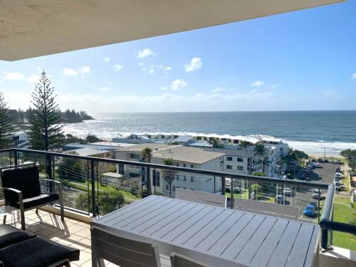 
a beach area with a balcony overlooking the ocean at Kings Row Apartments in Caloundra
